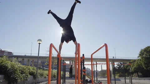 Low angle of a man balancing with one hand, handstand on the bar, in a barbel Stock Footage 147695630