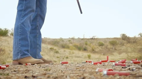 Low Angle of a Man in Cowboy Boots Shooting a Shotgun Stock Footage 87847776