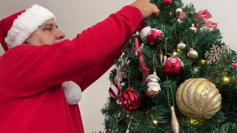 Low angle of man decorating Christmas tree Stock Footage 340334694