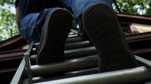 Low angle of Man as he climbs a ladder to clean gutters Stock Footage 338130448