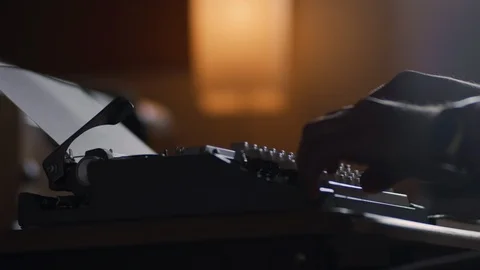 Low angle of a man typing at a vintage typewriter in slow motion 動画素材 97874569