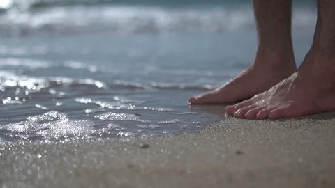 Low angle on man walking, stepping at beach. barefoot slow motion Stock Footage 100168648