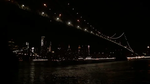 Low angle Manhattan Bridge cables and NYC skyline over East River at night Stock Footage 329170144