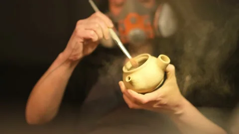 Low angle medium shot of female ceramic artist sanding teapot in the studio Stock Footage 236329000