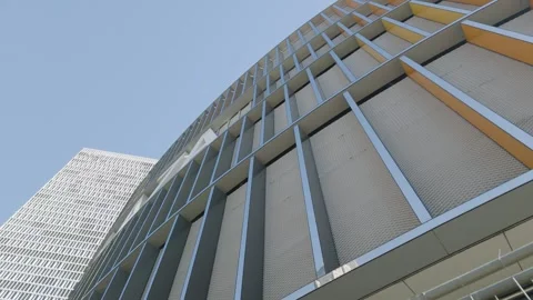 Low angle of modern curved glass building facade against blue sky, upward view Vídeo Stock 342029110