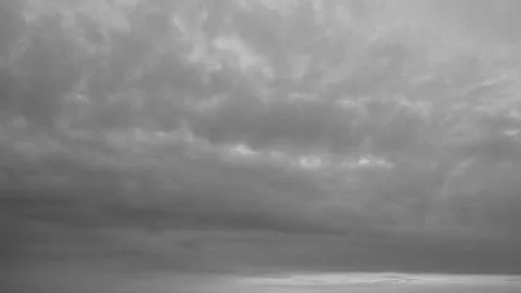 A low angle monochrome view captures a dense heavy dramatic storm cloud sky.. Stock Photos