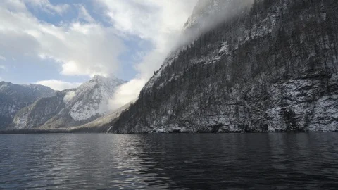 Low angle moving along large lake in snowy mountains in Koenigssee park Stock Footage 120979300