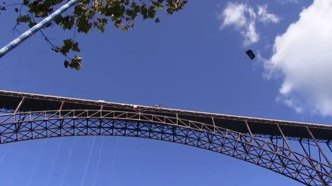 Low angle of New River Gorge Bridge with parachutist during annual Bridge Day Stock Footage 86476898
