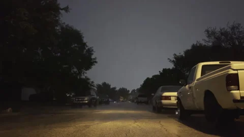 Low Angle at Night of Lightning Storm Over Rainy Neighborhood Street Stock Footage 313364996