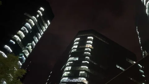 Low Angle Night Shot of Modern Skyscrapers with Glowing Lights 库存影片 334358264