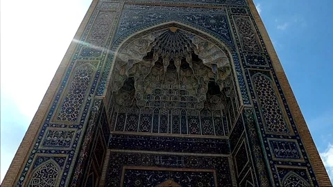 Low angle night/daytime tilt up of Gur-e-Amir mosaic portal with lens flare Stock Footage 336187984