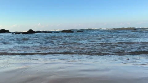 Low Angle Ocean Waves Washing on Sandy Beach Shoreline with Rocks Video stock 340338632