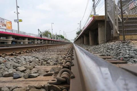 Low angle over train tracks past an empty railroad station platform on an ove Stock Photos