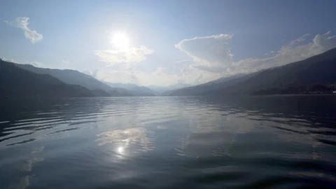 Low angle over water looking into the sun at Phewa Lake in Pokhara, Nepal Stock Footage 91166208
