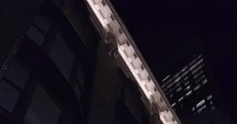 Low angle pan footage of New York City building fascia illuminated - 4K NYC Video stock 226675875