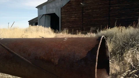 Low angle pan of landscape and debris near old abandoned grain elevator, Stock Footage 129325850