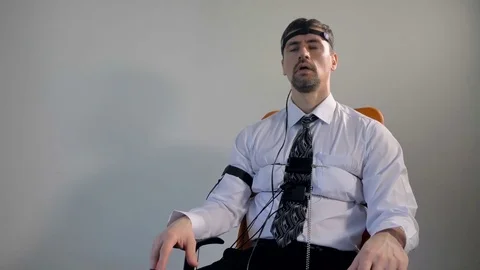 Low angle pan of the man connected to the lie detector circuit and answering Stock Footage 77129849