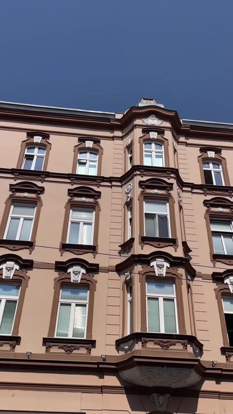 Low-angle pan revealing ornate facade and rooftop of historic urban building Stock Footage 344881937