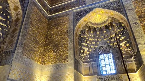Low angle pan right of golden ornate walls and muqarnas in Gur-e-Amir interior Stock Footage 336188055