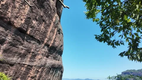 Low angle panning shot of majestic sandstone cliffs and green foliage Stock Footage 339638009