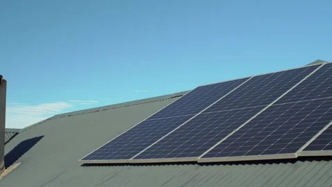 Low angle panning view of solar panels on corrugated iron roof with chimney Stock Footage 336287271