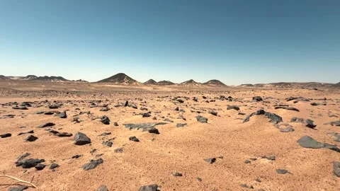 Low angle panorama of volcanic black basalt stones in the sand in the desert Stock Footage 340868744
