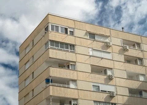 Low-angle partial view of an old building facade under the blue cloudy sky Stock Photos