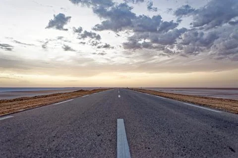 Low Angle Perspective of Empty Straight Highway Stretching Across Flat Salt.. Stock Photos