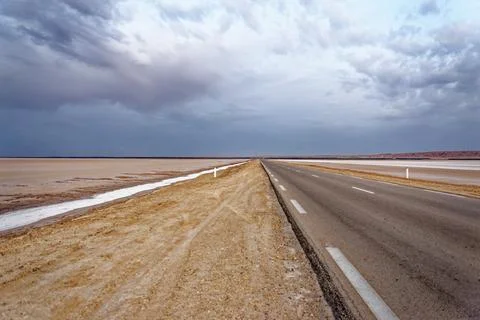 Low Angle Perspective of Empty Straight Highway Stretching Across Flat Salt.. Stock Photos