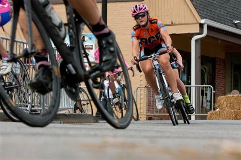 Low-angle perspective of female cyclists racing into turn Stock Photos