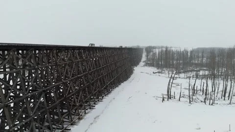 Low Angle Perspective of a Long Train Trestle Bridge Covered in Snow Stock Footage 337250591