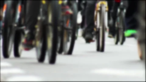 Low angle perspective of many cyclists riding bicycles in large group, wheels Stock Footage 340386746