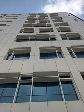 Low-angle perspective of modern white office building facade against sky Foto stock