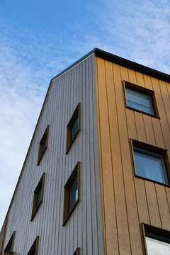 A low-angle perspective shot of a modern multi-story residential building fea Stock Photos