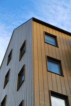 A low-angle perspective shot of a modern multi-story residential building fea Stock Photos