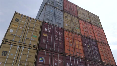 Low-angle perspective of towering freight containers stacked at the industrial Stockbeeldmateriaal 345101557