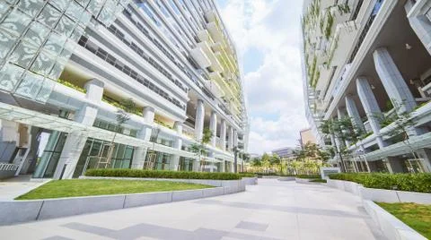 Low angle perspective view of empty pavement and modern office building with  Stock Photos