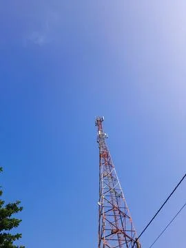 Low angle portrait of communication tower, cables and leaves in the corner Stock Photos