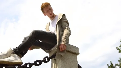Low angle portrait of confident stylish man sitting marble staircase against Stock Footage 79082270