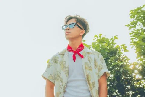 Low angle portrait of confident young Asian man in vintage summer outfit st.. Stock Photos