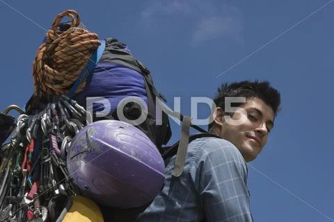 Low angle portrait of man carrying backpack and equipment Stock Photos