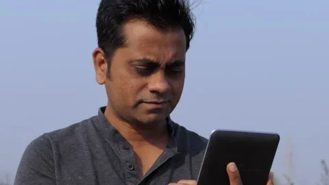 Low angle portrait shot of a middle aged indian man using a tablet, unhappy Stock Footage 148439154