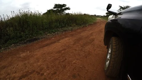 Low angle POV car tire driving in Africa on dirt road Video stock 106963255