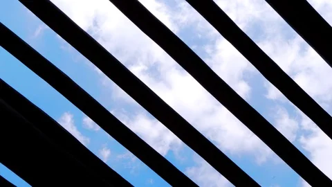 Low angle pov of clouds timelapse behind a wood pergola. Stock Footage 121224119