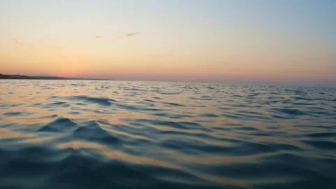 Low angle pov moving forward on seawater surface at sunset Stock Footage 279430716