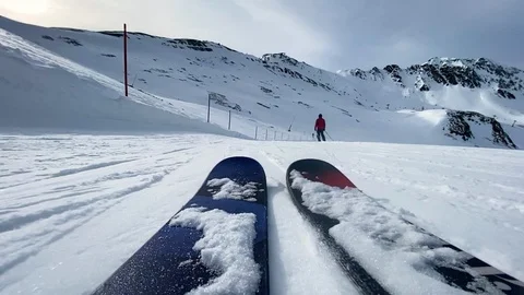 Low angle POV slowly skiing down a flat ski slope on a ski resort. Vidéo 124063111