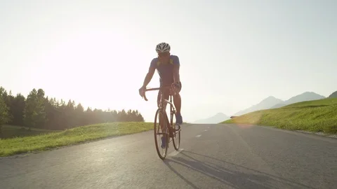 LOW ANGLE: Pro biker man with sunglasses pushes himself to reach the finish line Stock Footage 86876418
