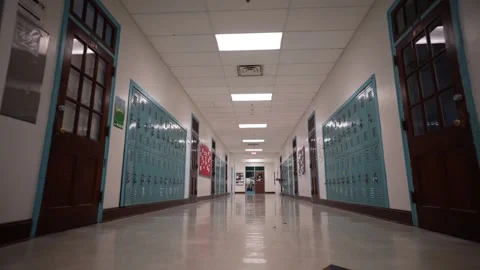 Low angle push in down a long empty high school corridor hallway lined with Stock Footage 245103628