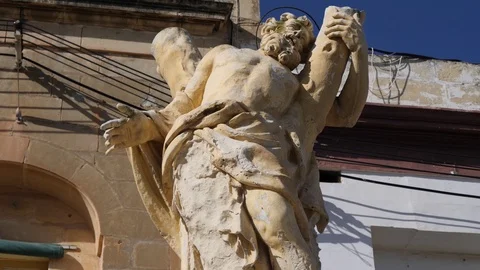 Low angle of a religious statue in front of buildings Stock Footage 90317867