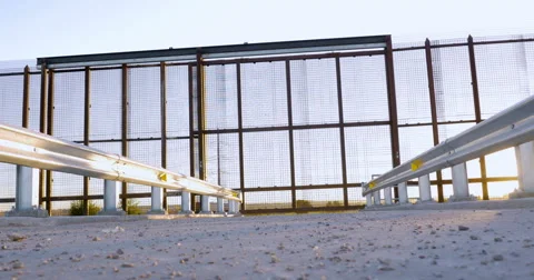 Low Angle Reveals a Gate in a Large Metal Wall on the Borderline Stock Footage 67653465